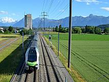 Durchfahrt BLS-Zug mit LANDI-Turm und Bergkette im Hintergrund